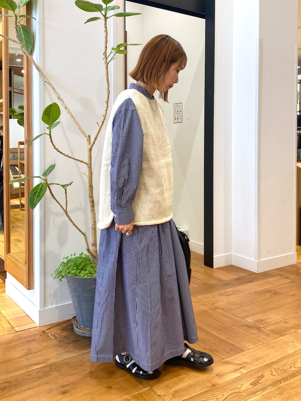 ブルー系のワンピース、ブラック系のバックパック/リュック、ホワイト系のベストを着用したレディースの秋コーディネートの3枚目の写真