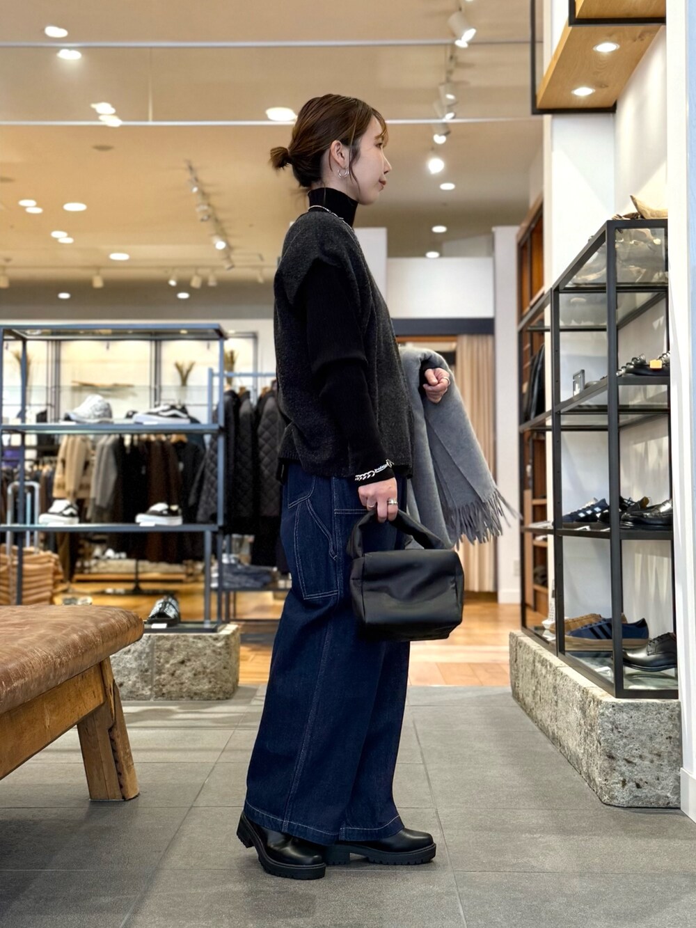 グレー系のニット/セーター、ブルー系のデニムパンツ、ブラック系のニット/セーターを着用したレディースの冬コーディネートの4枚目の写真