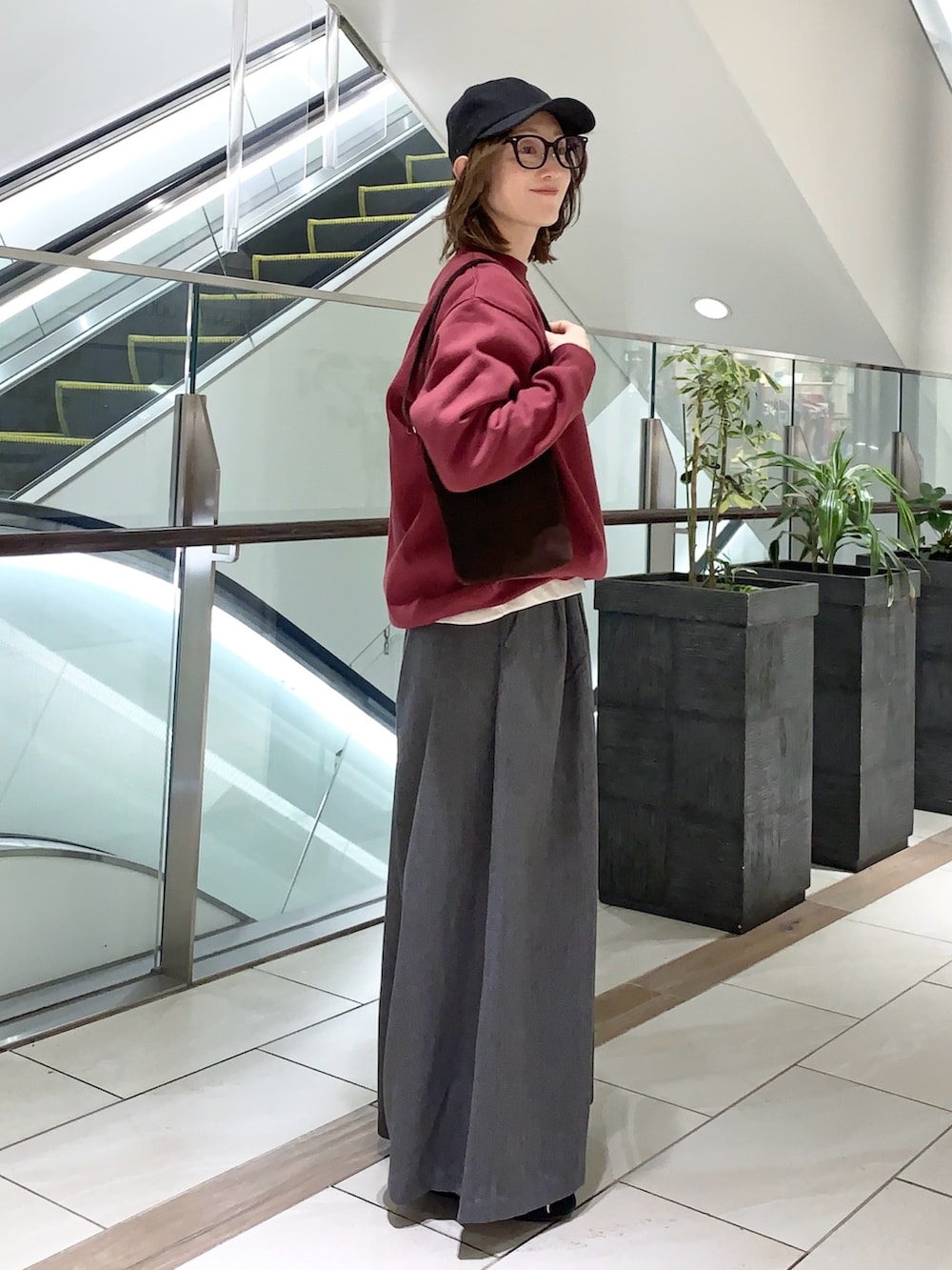 グレー系のその他パンツ、レッド系のスウェット、ブラウン系のショルダーバッグを着用したレディースの冬コーディネートの5枚目の写真