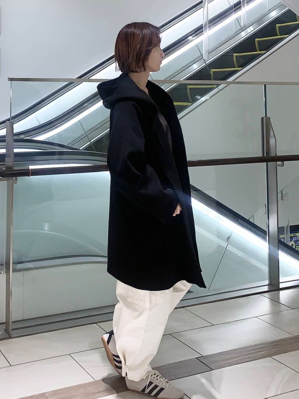 ホワイト系のその他パンツ、ブラウン系のショルダーバッグ、ブラック系のその他アウターを着用したレディースの冬コーディネートの2枚目の写真