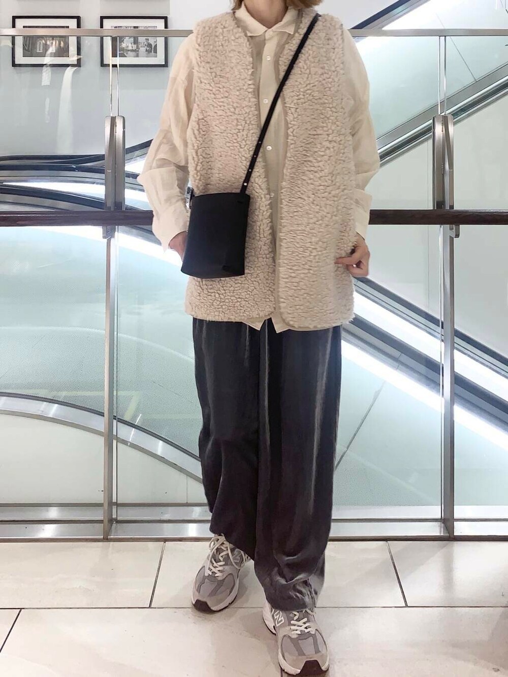 ベージュ系のベスト、ブラック系のショルダーバッグ、ベージュ系のシャツ/ブラウスを着用したレディースの秋コーディネートの6枚目の写真