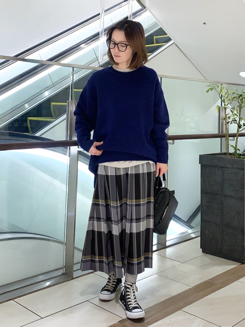 ブルー系のニット/セーター、ブラック系のスカート、ブラック系のショルダーバッグを着用したレディースの冬コーディネートの4枚目の写真
