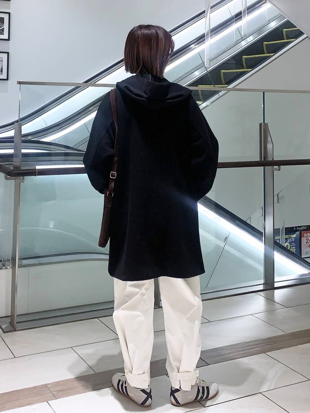 ホワイト系のその他パンツ、ブラウン系のショルダーバッグ、ブラック系のその他アウターを着用したレディースの冬コーディネートの3枚目の写真