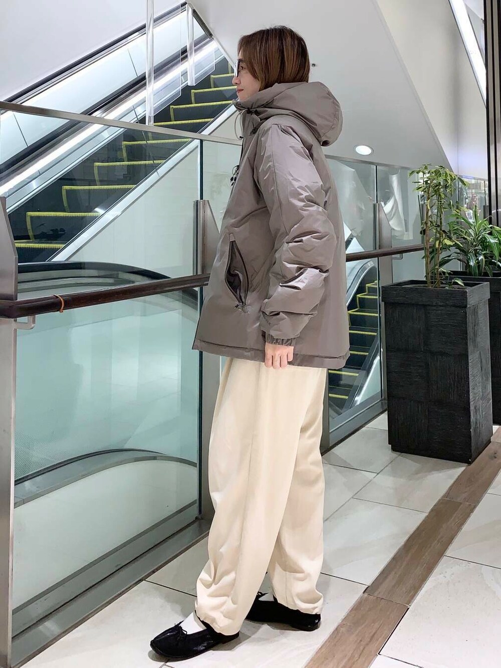 ホワイト系のTシャツ/カットソー、ブラウン系のダウンジャケット/コート、ブラック系のバレエシューズを着用したレディースの秋コーディネートの4枚目の写真