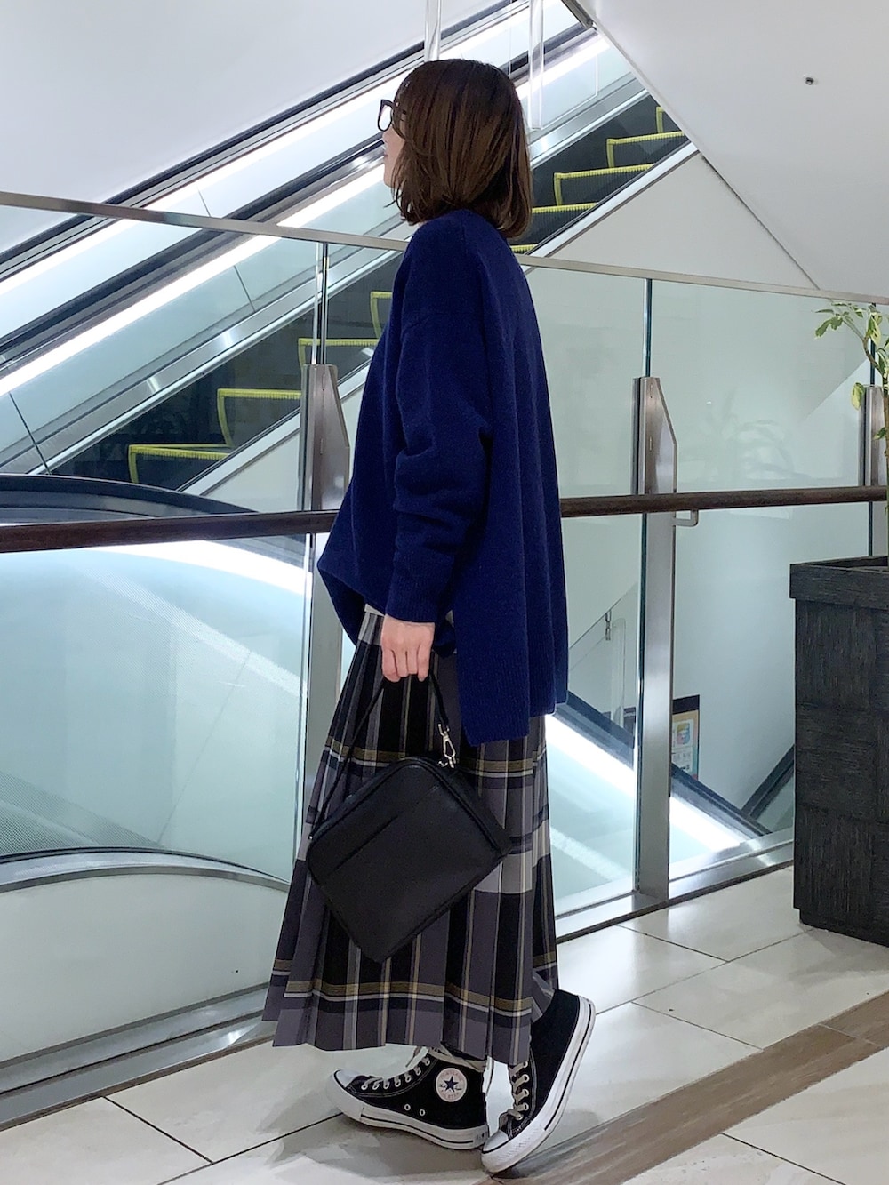 ブルー系のニット/セーター、ブラック系のスカート、ブラック系のショルダーバッグを着用したレディースの冬コーディネートの2枚目の写真