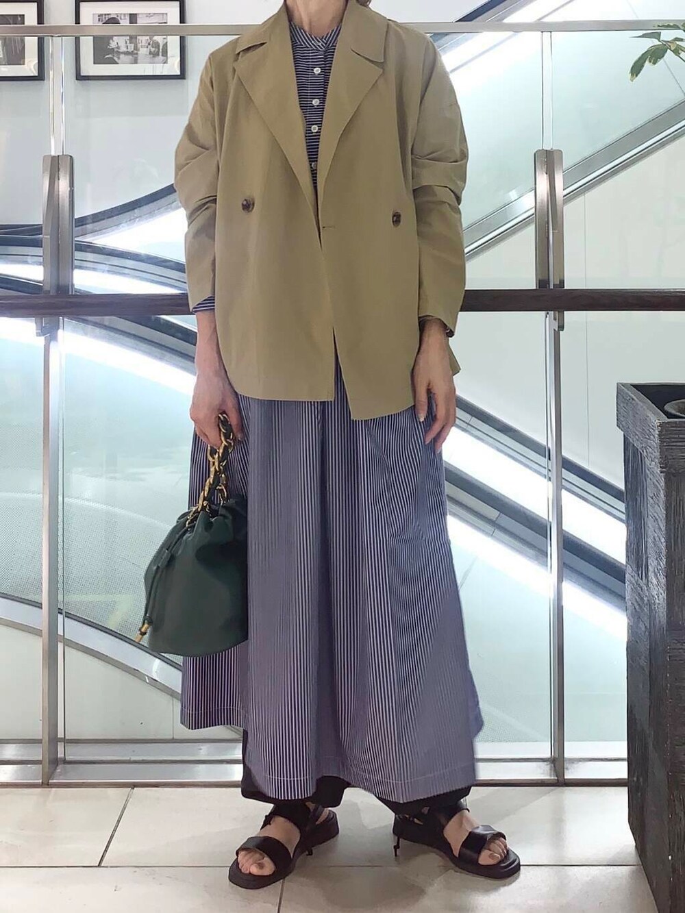 ブラック系のサンダル、グリーン系のショルダーバッグ、ブルー系のワンピースを着用したレディースの夏コーディネートの7枚目の写真