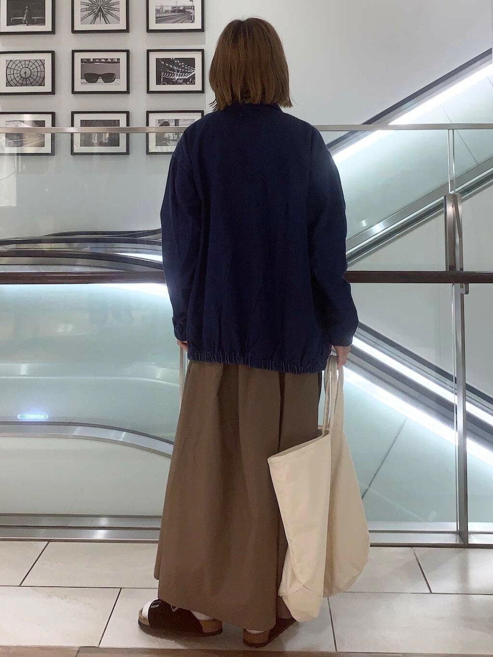 ホワイト系のトートバッグ、ブルー系のデニムジャケット、ホワイト系のシャツ/ブラウスを着用したレディースの夏コーディネートの4枚目の写真