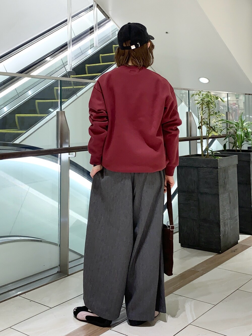 グレー系のその他パンツ、レッド系のスウェット、ブラウン系のショルダーバッグを着用したレディースの冬コーディネートの3枚目の写真