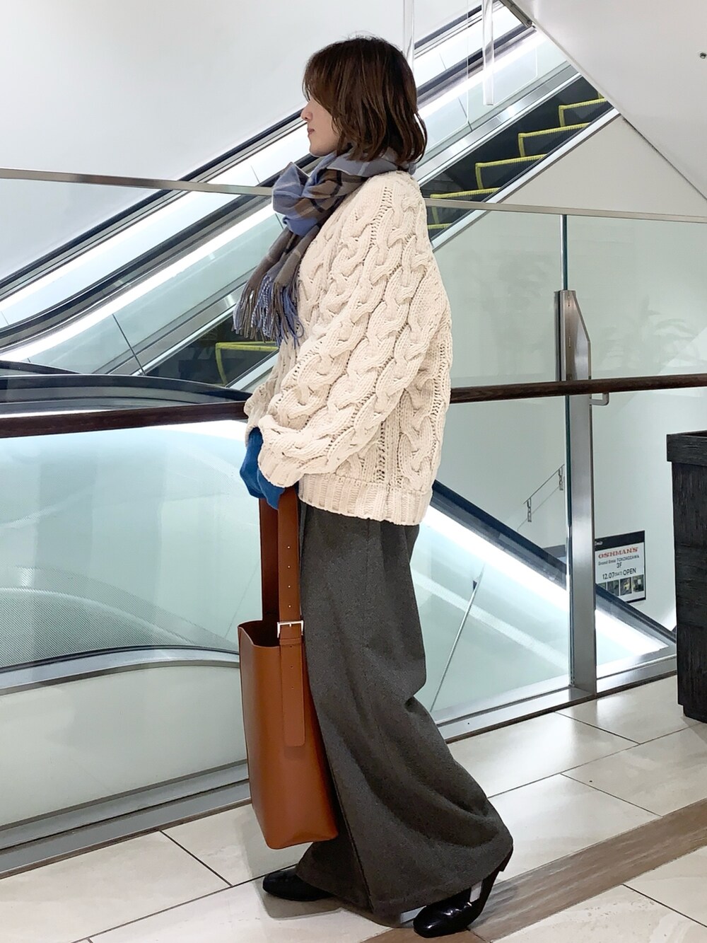 ホワイト系のトップス、グレー系のその他パンツ、ブラウン系のトートバッグを着用したレディースの冬コーディネートの3枚目の写真