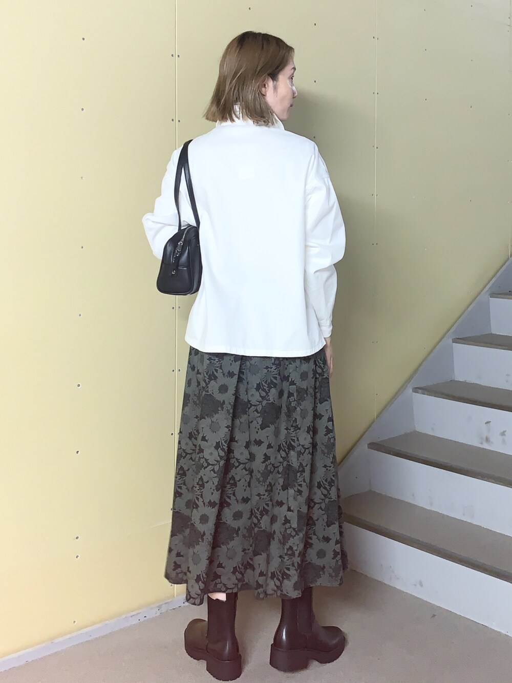 ブラック系のスカート、ホワイト系のトップス、ホワイト系のTシャツ/カットソーを着用したレディースの秋コーディネートの3枚目の写真