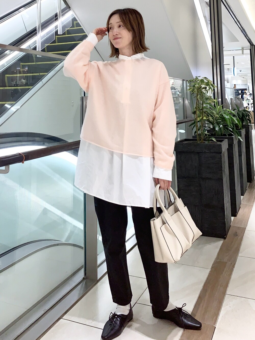 ピンク系のニット/セーター、ブラック系のその他パンツ、ホワイト系のシャツ/ブラウスを着用したレディースの秋コーディネートの5枚目の写真