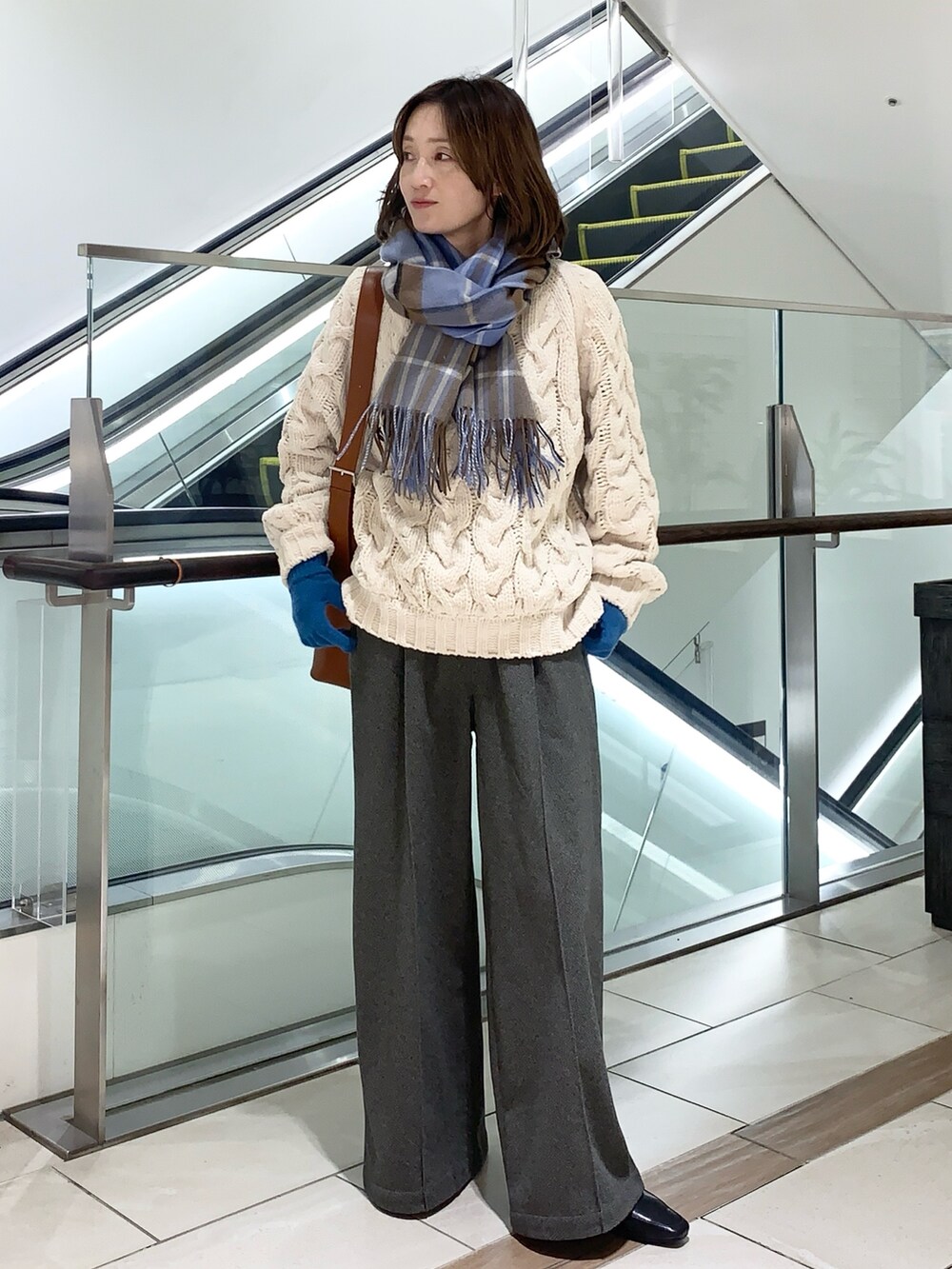 ホワイト系のトップス、グレー系のその他パンツ、ブラウン系のトートバッグを着用したレディースの冬コーディネートの2枚目の写真