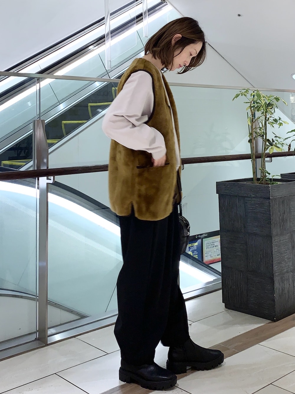 ベージュ系のベスト、グレー系のスウェット、ブラック系のその他パンツを着用したレディースの冬コーディネートの3枚目の写真