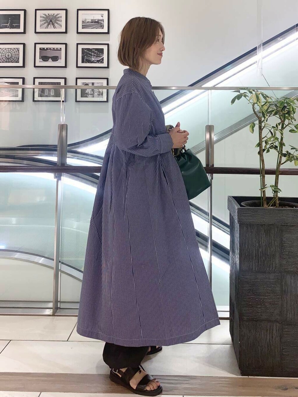 ブラック系のサンダル、グリーン系のショルダーバッグ、ブルー系のワンピースを着用したレディースの夏コーディネートの3枚目の写真