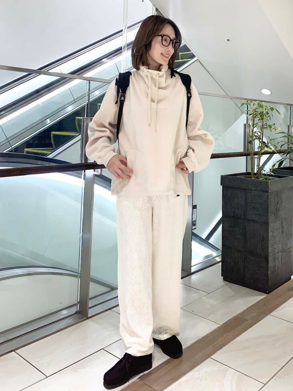 ブラウン系のステンカラーコート、ホワイト系のその他パンツ、ホワイト系のその他トップスを着用したレディースの冬コーディネートの2枚目の写真