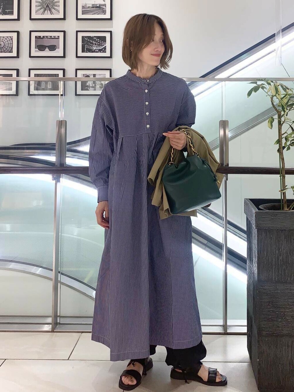 ブラック系のサンダル、グリーン系のショルダーバッグ、ブルー系のワンピースを着用したレディースの夏コーディネートの2枚目の写真