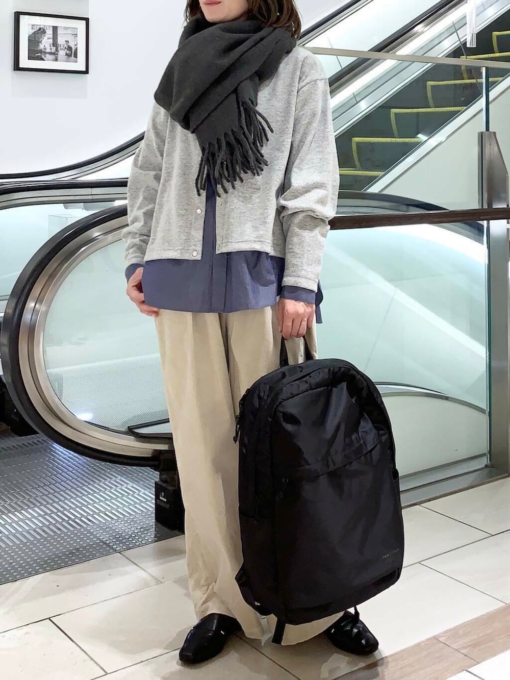 ブラック系のバックパック/リュック、ブルー系のダウンジャケット/コート、ブルー系のシャツ/ブラウスを着用したレディースの冬コーディネートの6枚目の写真