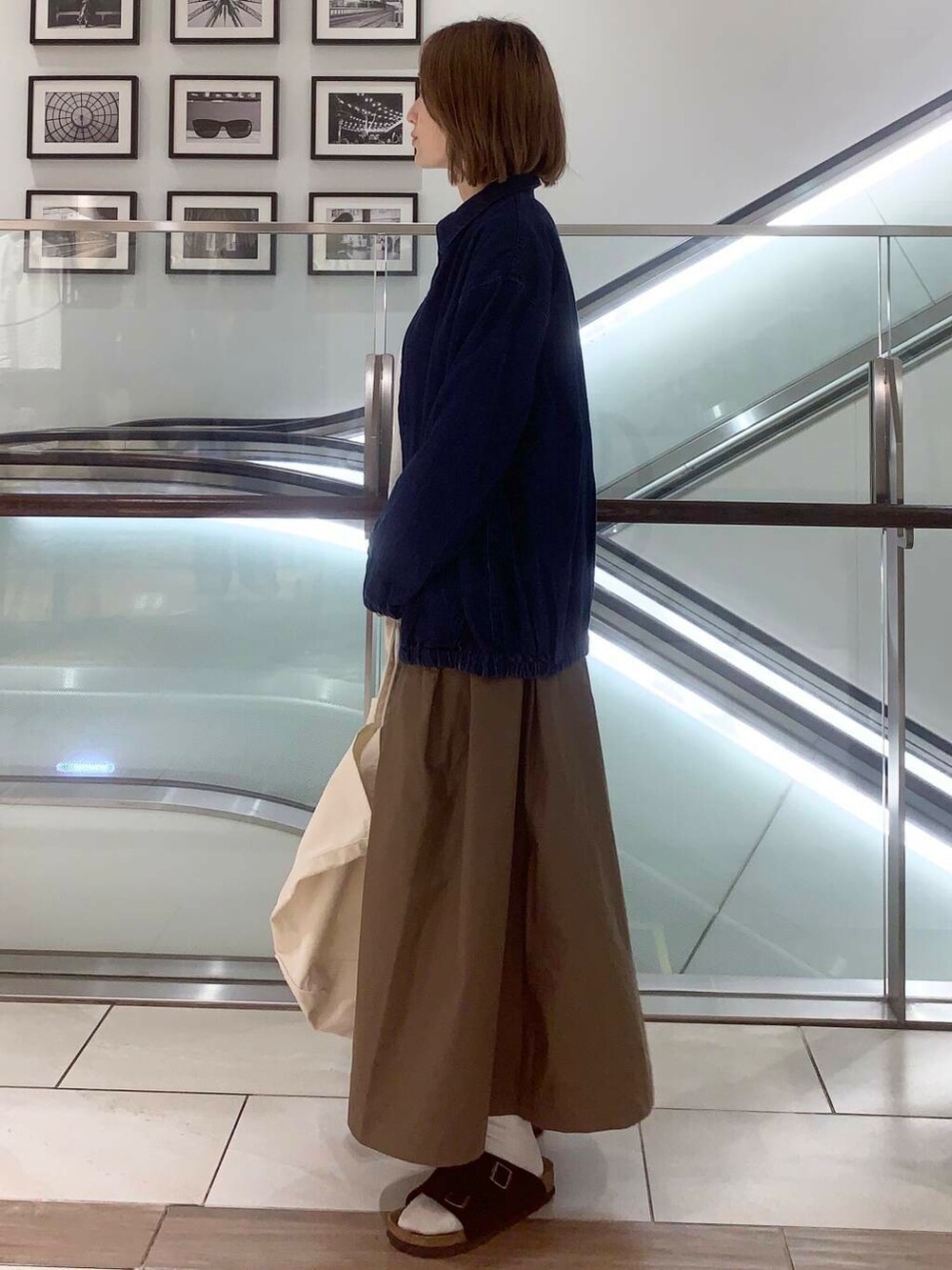 ホワイト系のトートバッグ、ブルー系のデニムジャケット、ホワイト系のシャツ/ブラウスを着用したレディースの夏コーディネートの6枚目の写真