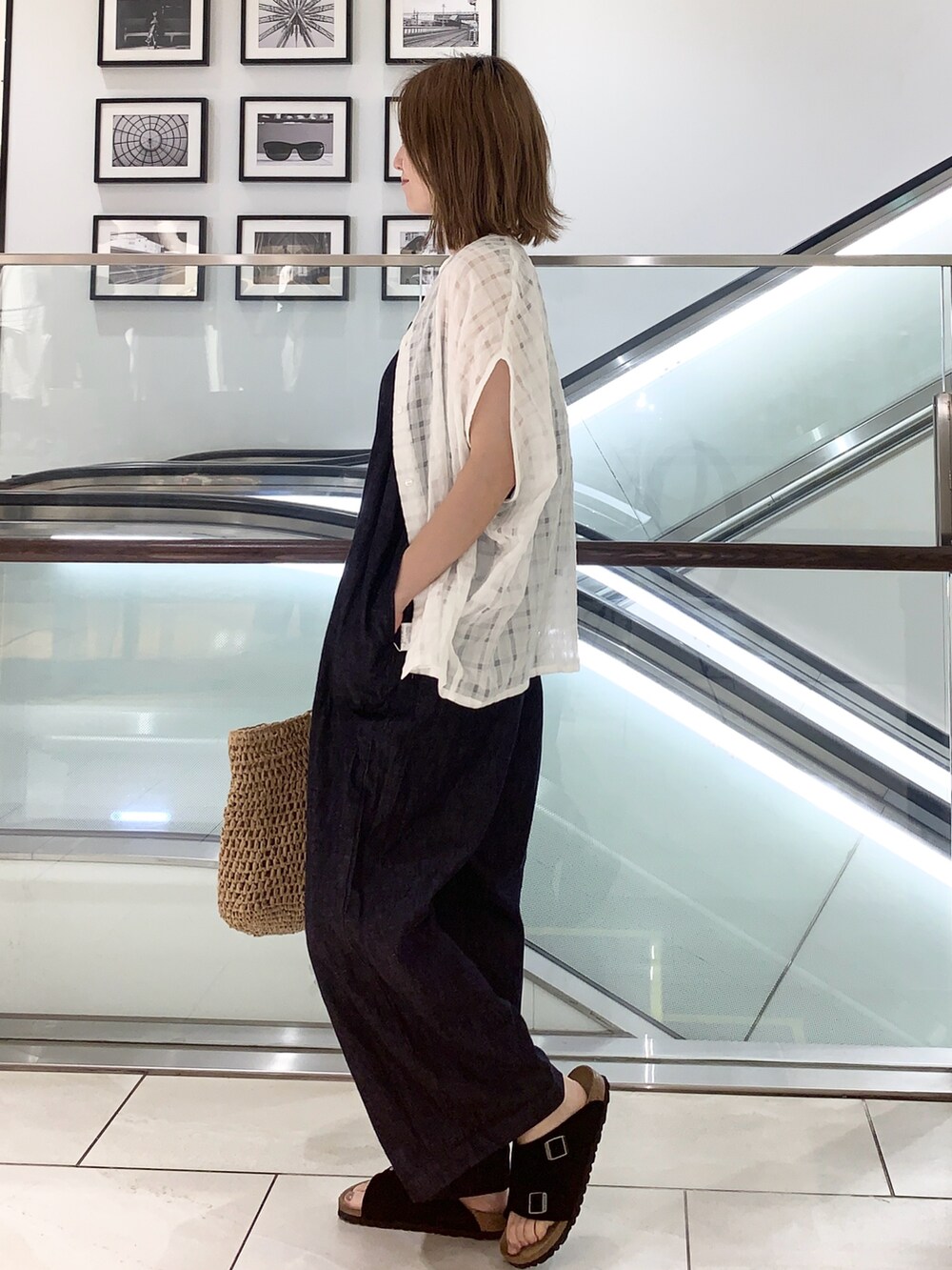 ベージュ系のサンダル、ブルー系のサロペット/オーバーオール、ホワイト系のシャツ/ブラウスを着用したレディースの夏コーディネートの2枚目の写真