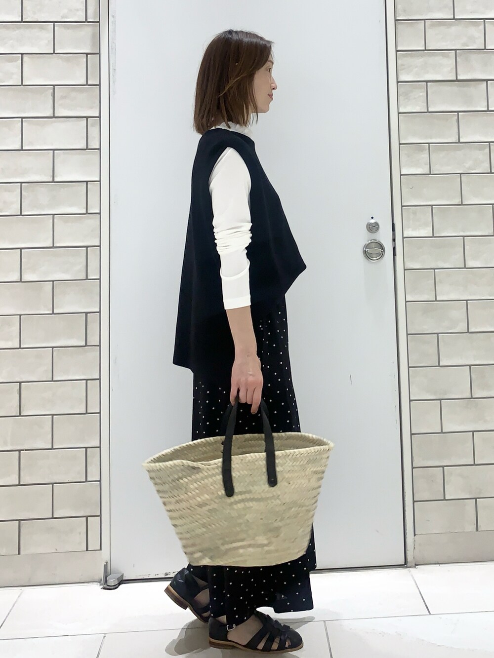 ブラック系のサンダル、ブラック系のその他パンツ、ベージュ系のバッグを着用したレディースの春コーディネートの2枚目の写真