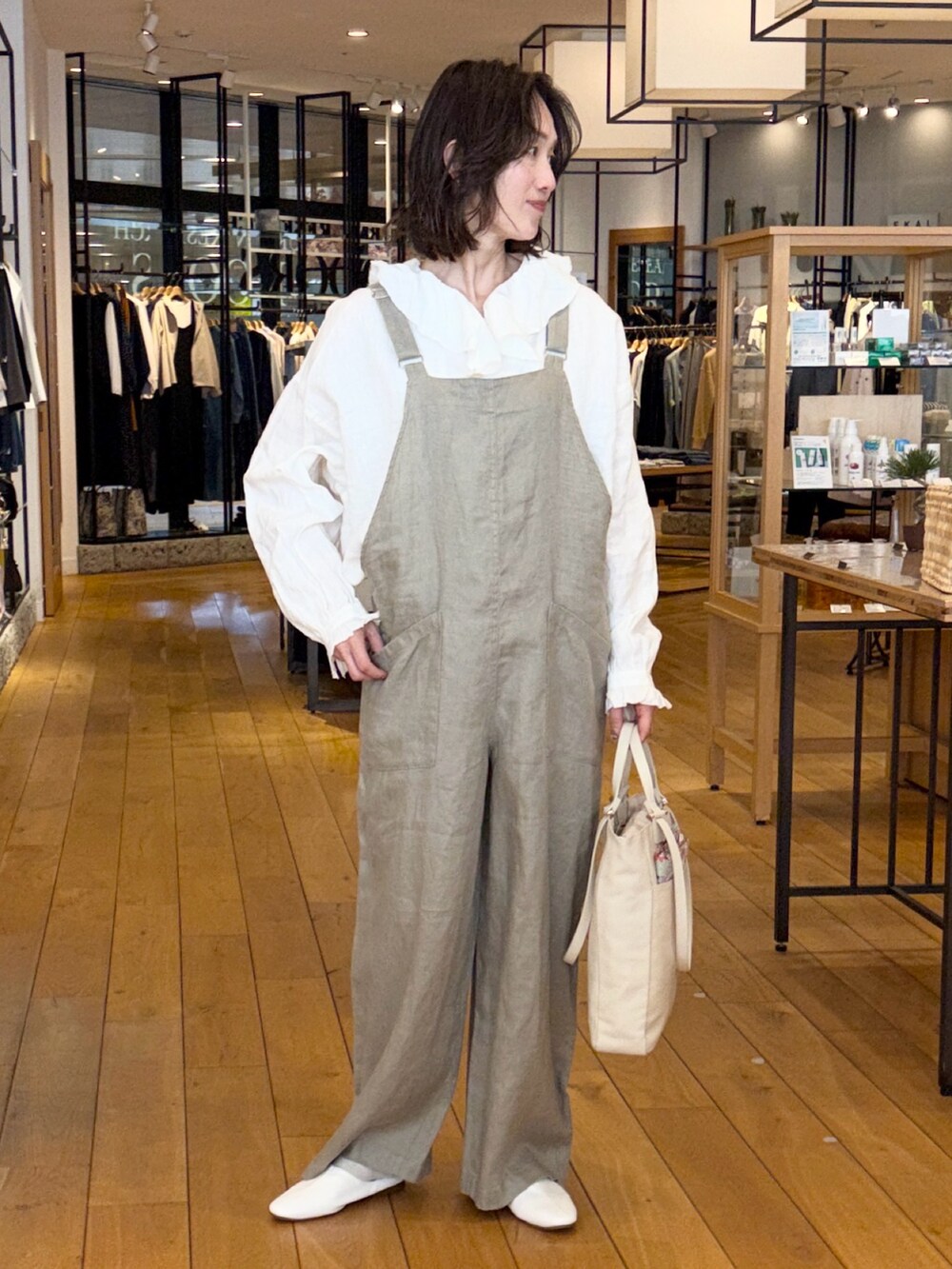 ブラック系のその他アウター、ホワイト系のシャツ/ブラウス、グレー系のサロペット/オーバーオールを着用したレディースの春コーディネートの4枚目の写真