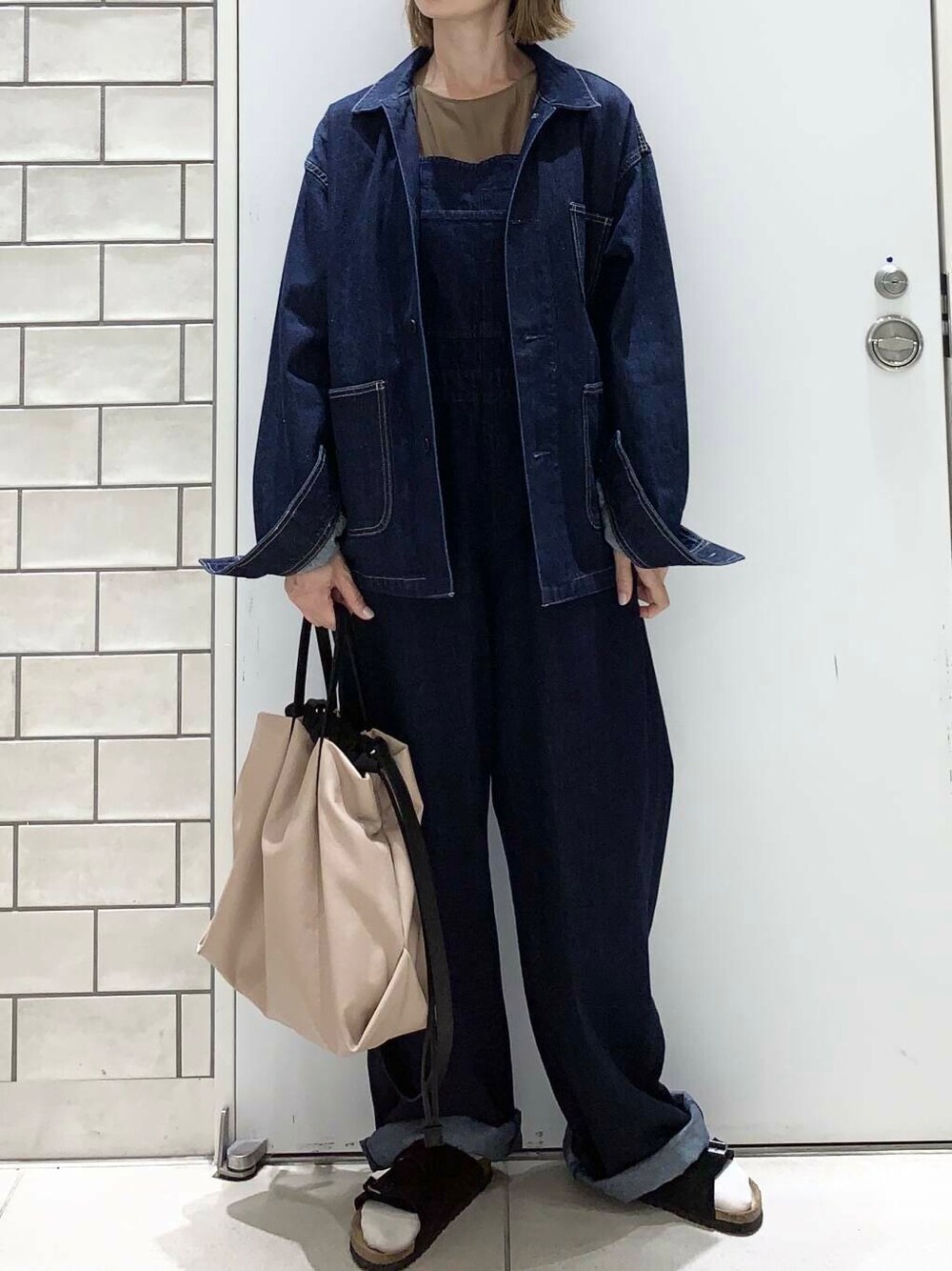 ベージュ系のトートバッグ、イエロー系のタンクトップ、ブルー系のデニムジャケットを着用したレディースの夏コーディネートの5枚目の写真