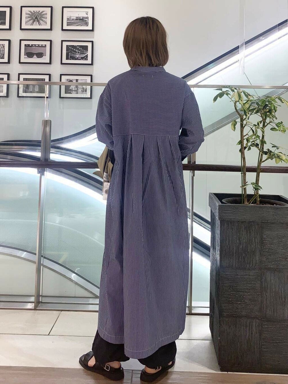 ブラック系のサンダル、グリーン系のショルダーバッグ、ブルー系のワンピースを着用したレディースの夏コーディネートの4枚目の写真