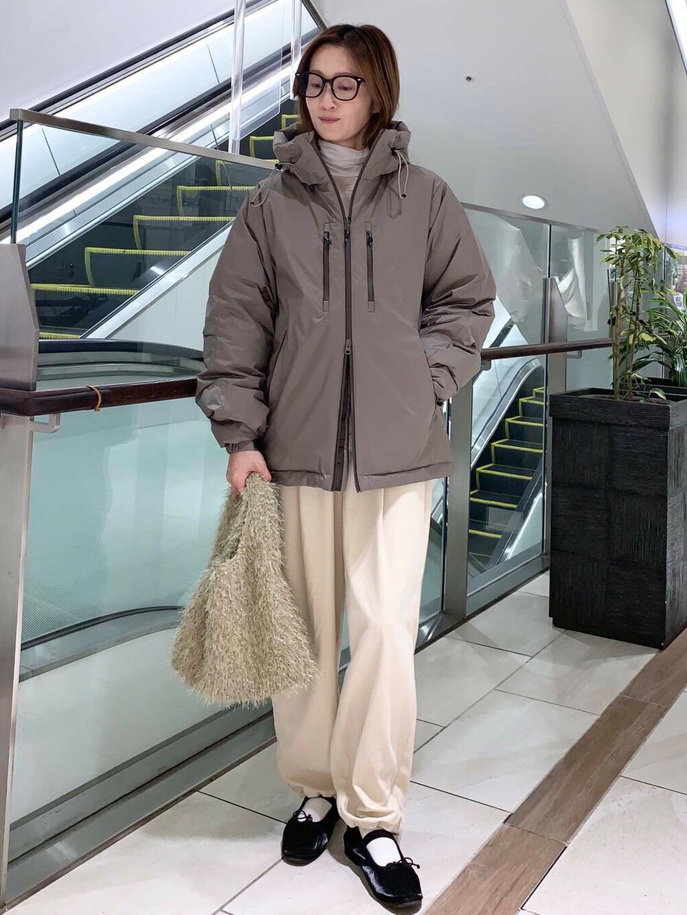 ホワイト系のTシャツ/カットソー、ブラウン系のダウンジャケット/コート、ブラック系のバレエシューズを着用したレディースの秋コーディネートの3枚目の写真