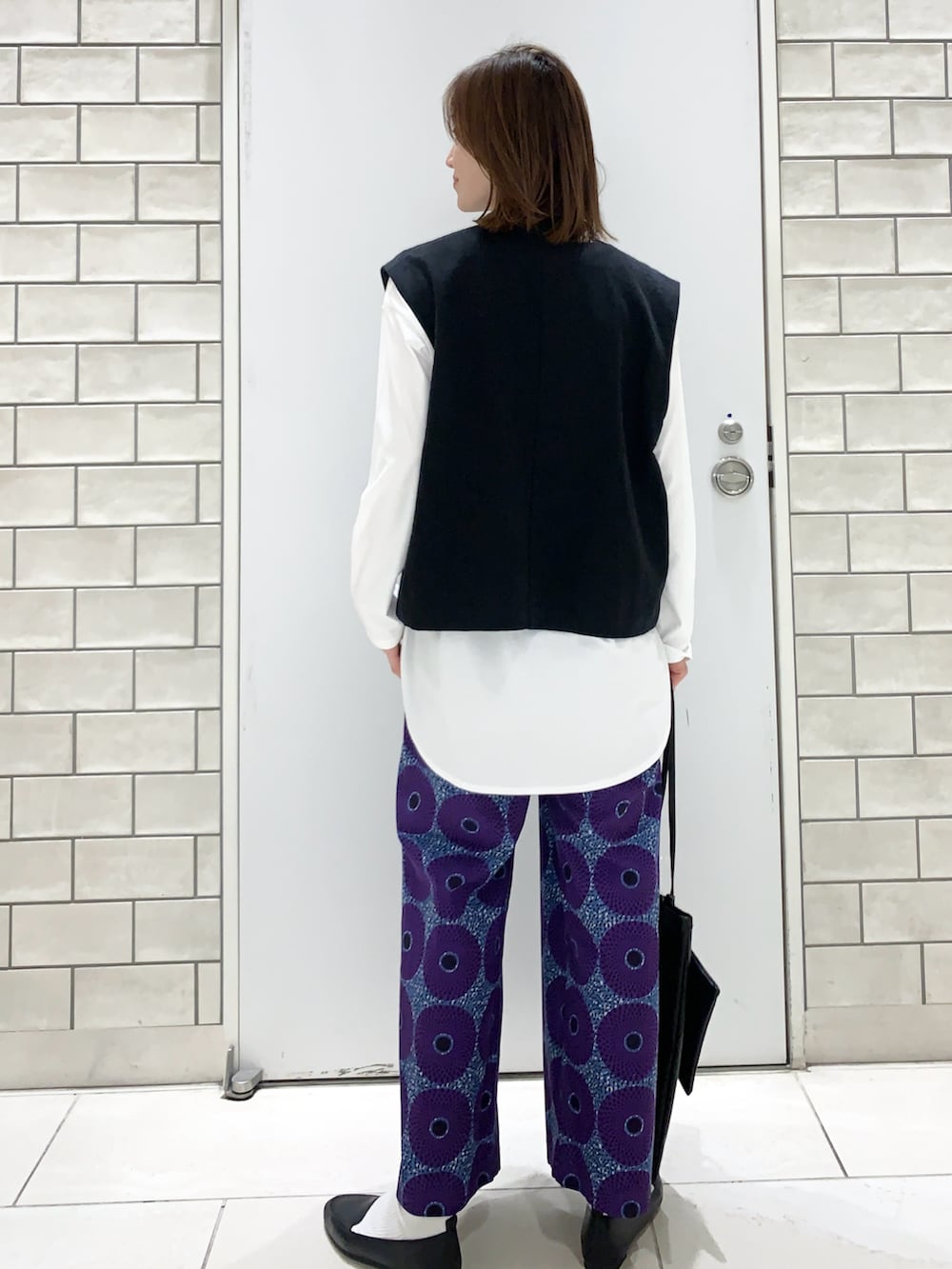 パープル系のその他パンツ、ブラック系のスリッポン、ブラック系のベストを着用したレディースの春コーディネートの3枚目の写真