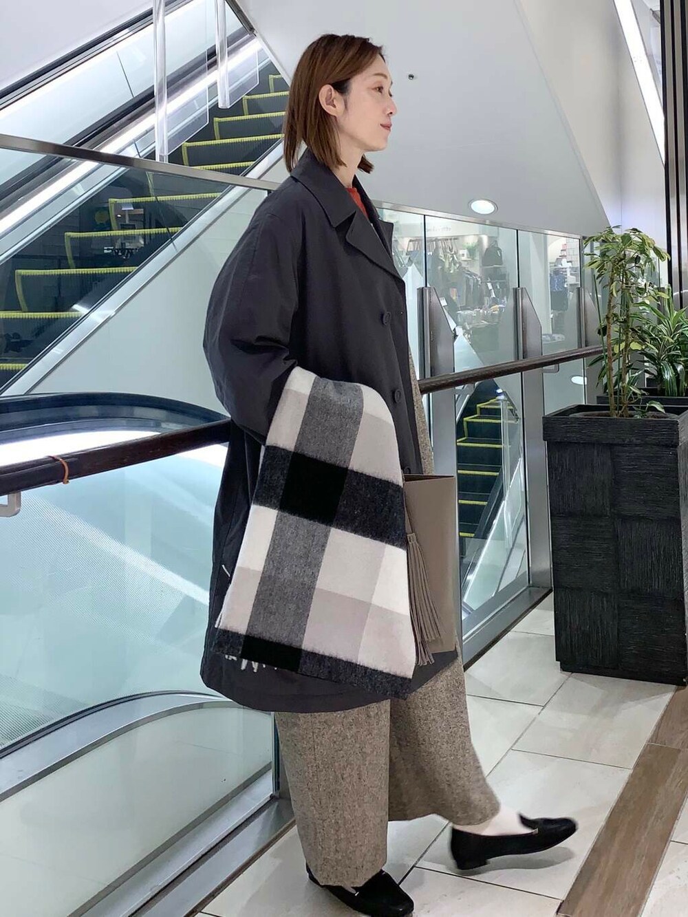 ブラック系のローファー、ブラック系のボストンバッグ、オレンジ系のニット/セーターを着用したレディースの秋コーディネートの2枚目の写真