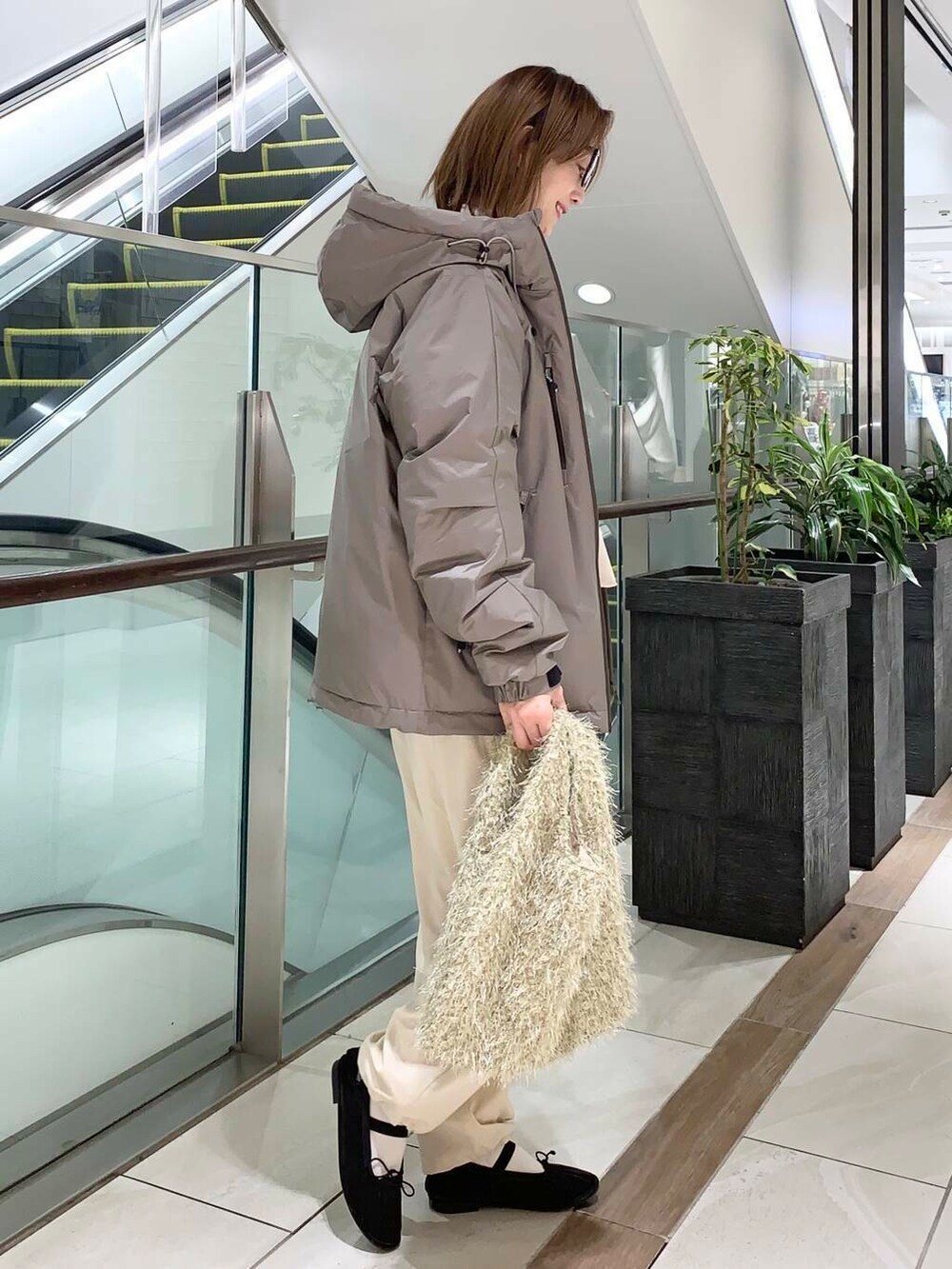 ホワイト系のTシャツ/カットソー、ブラウン系のダウンジャケット/コート、ブラック系のバレエシューズを着用したレディースの秋コーディネートの2枚目の写真