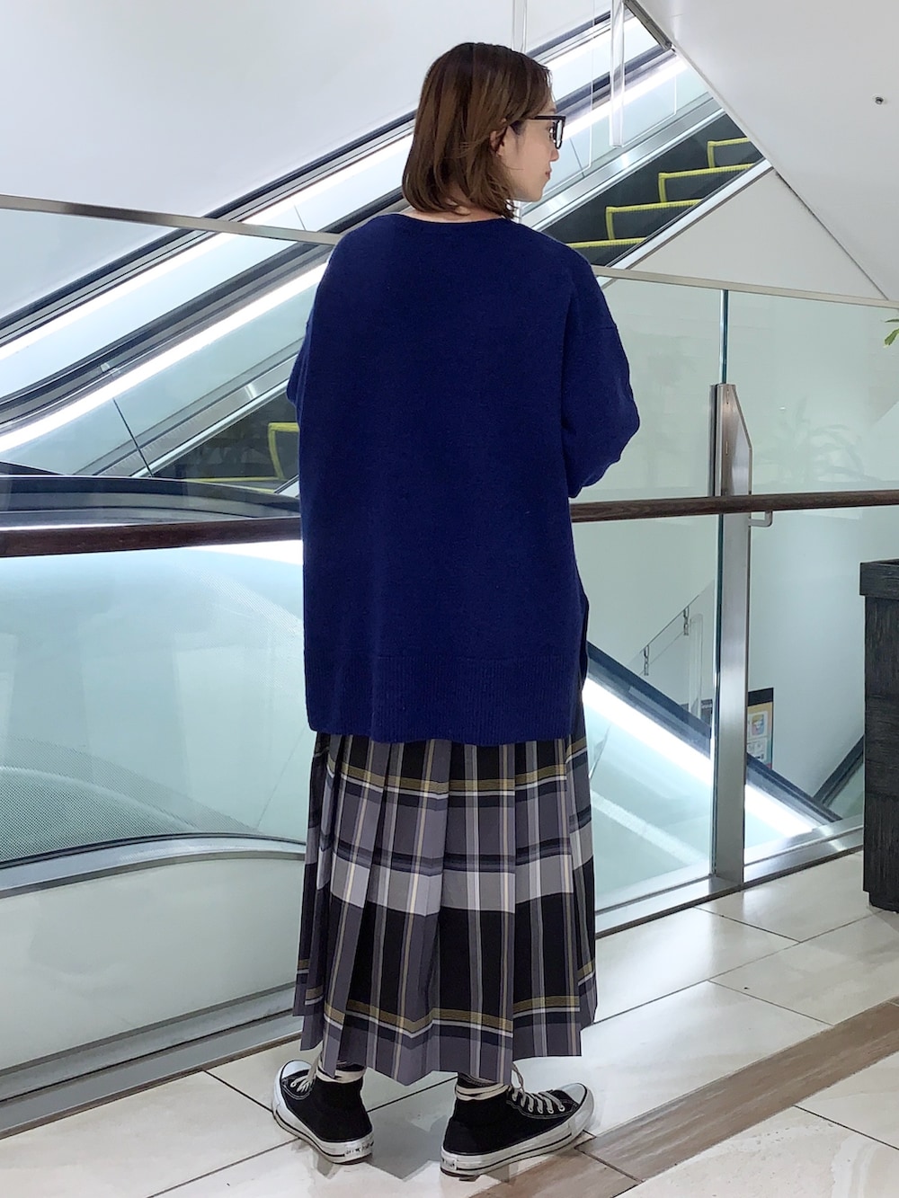 ブルー系のニット/セーター、ブラック系のスカート、ブラック系のショルダーバッグを着用したレディースの冬コーディネートの3枚目の写真