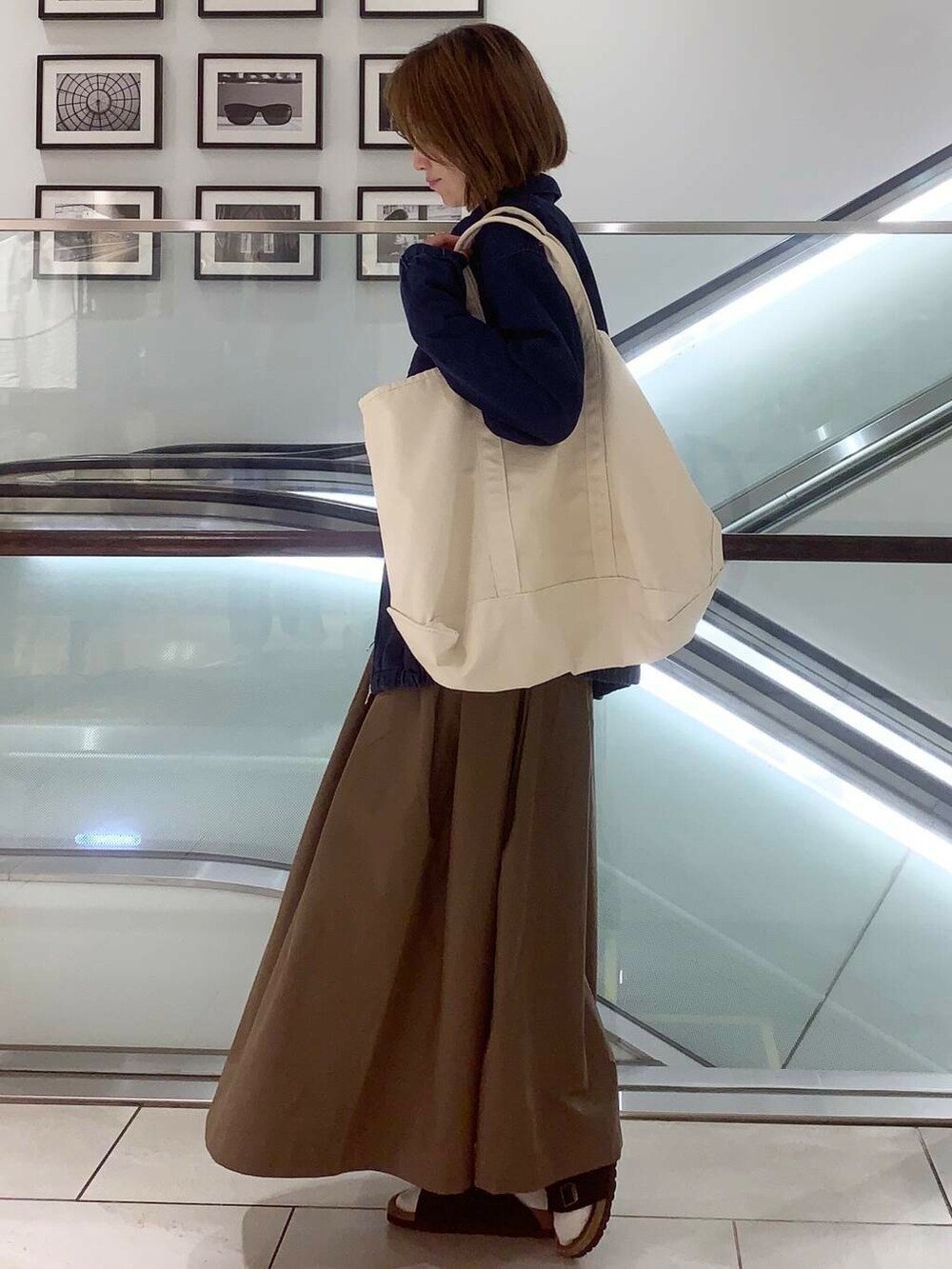 ホワイト系のトートバッグ、ブルー系のデニムジャケット、ホワイト系のシャツ/ブラウスを着用したレディースの夏コーディネートの5枚目の写真