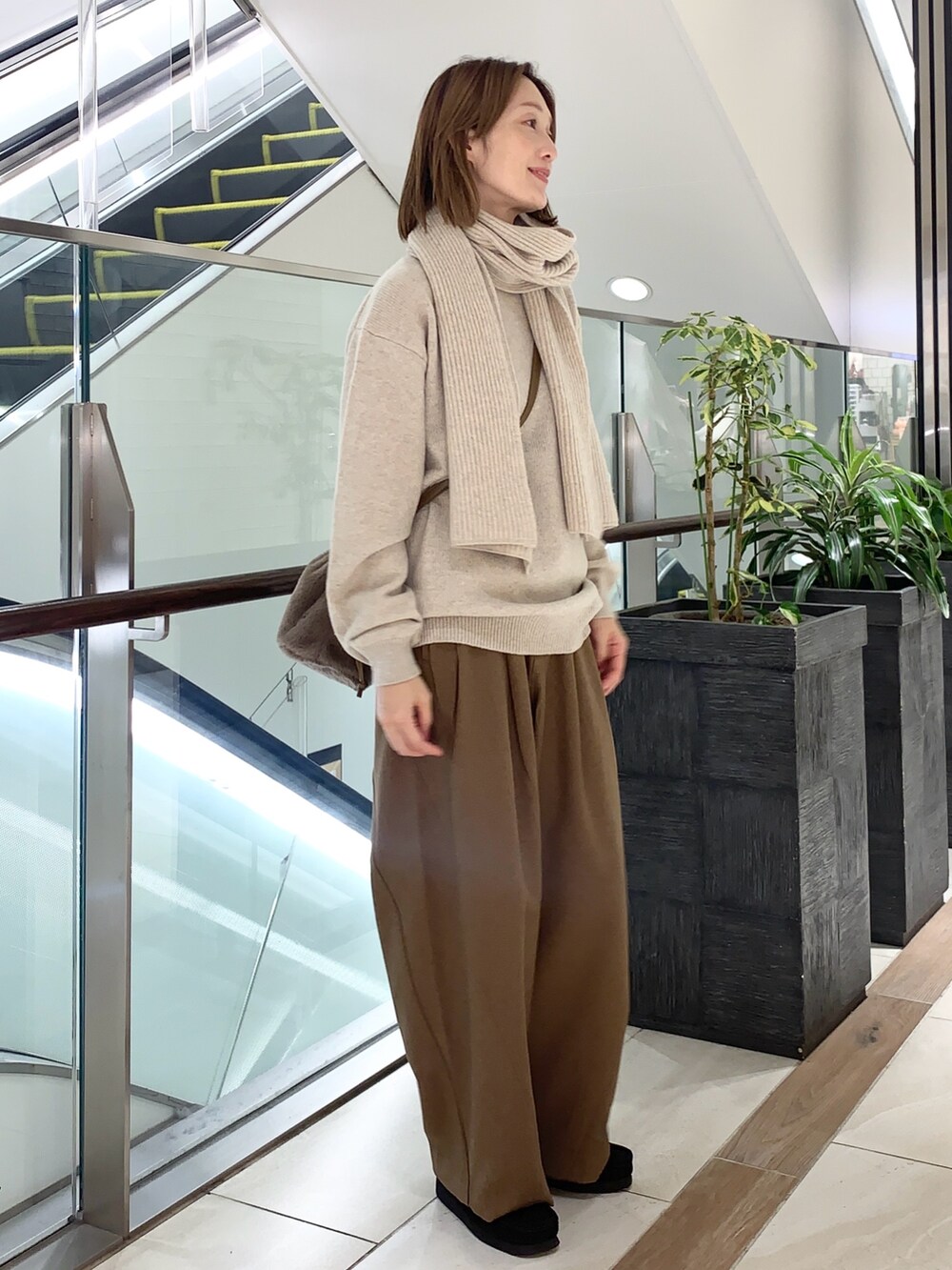 グレー系のその他パンツ、ベージュ系のニット/セーター、ブラウン系のショルダーバッグを着用したレディースの秋コーディネートの2枚目の写真