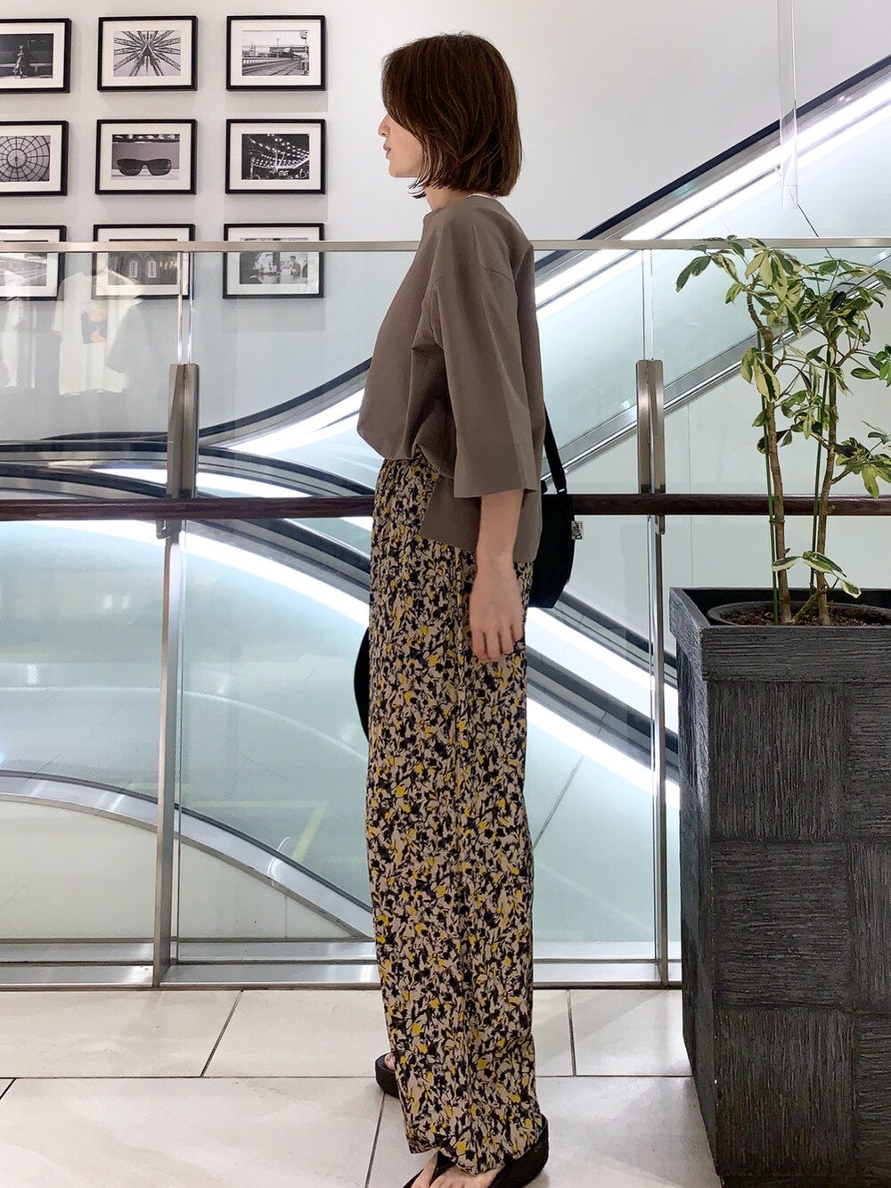 ブラック系のサンダル、その他のパンツ、ブラック系のショルダーバッグを着用したレディースの春コーディネートの2枚目の写真