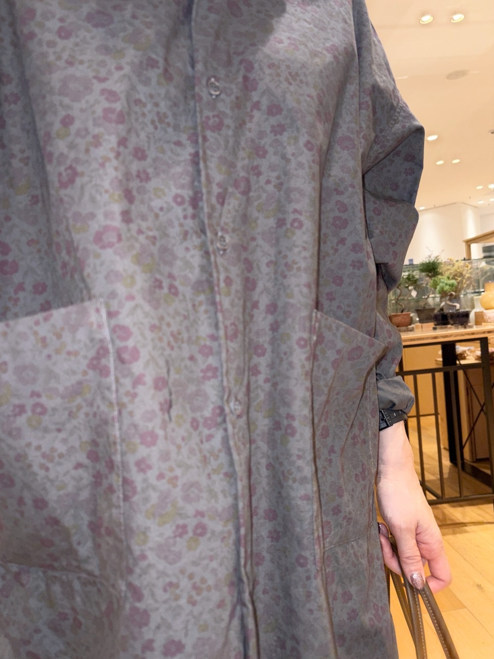 グレー系のシャツ/ブラウス、ホワイト系のスカート、ブラウン系のトートバッグを着用したレディースの秋コーディネートの5枚目の写真