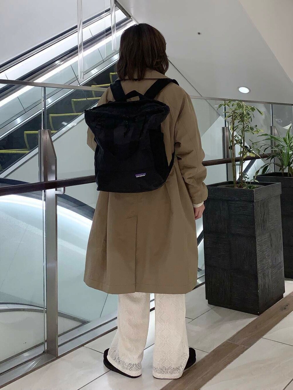 ブラウン系のステンカラーコート、ホワイト系のその他パンツ、ホワイト系のその他トップスを着用したレディースの冬コーディネートの5枚目の写真