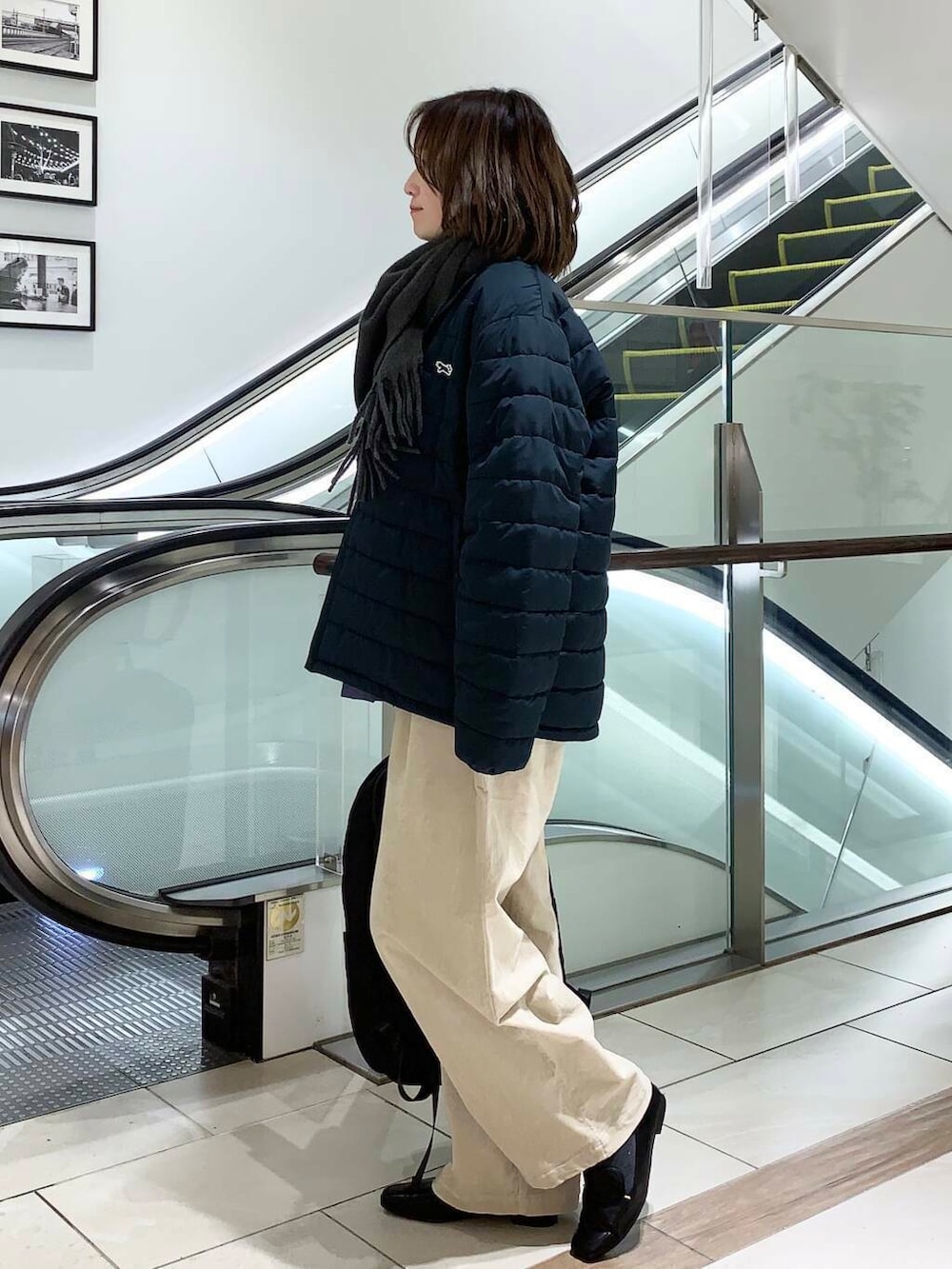 ブラック系のバックパック/リュック、ブルー系のダウンジャケット/コート、ブルー系のシャツ/ブラウスを着用したレディースの冬コーディネートの4枚目の写真