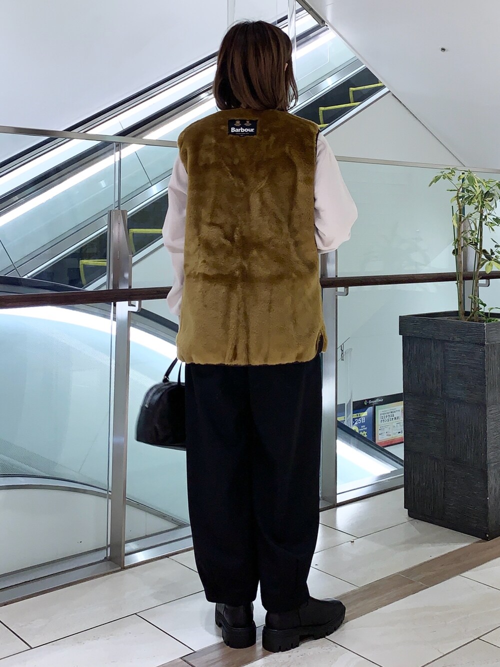 ベージュ系のベスト、グレー系のスウェット、ブラック系のその他パンツを着用したレディースの冬コーディネートの4枚目の写真