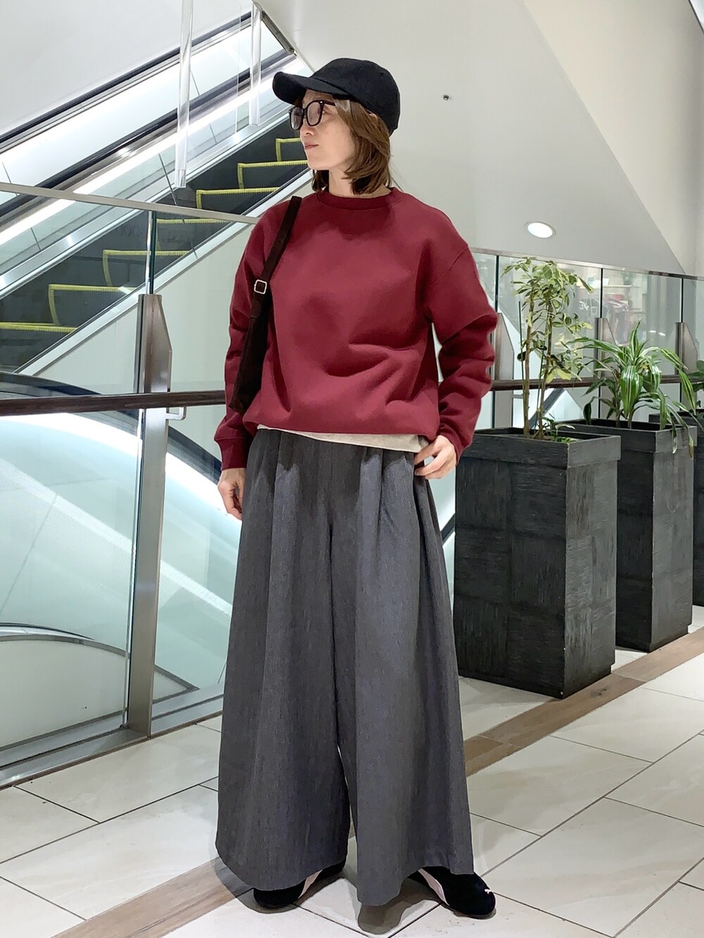 グレー系のその他パンツ、レッド系のスウェット、ブラウン系のショルダーバッグを着用したレディースの冬コーディネートの4枚目の写真