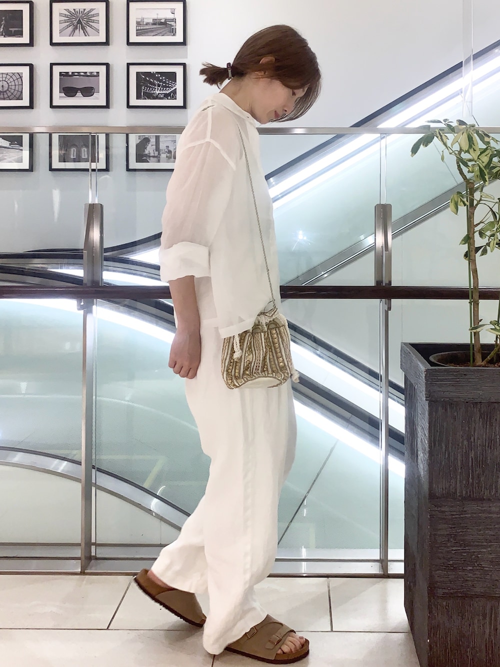 ホワイト系のサンダル、ホワイト系のその他パンツ、ホワイト系のショルダーバッグを着用したレディースの夏コーディネートの2枚目の写真