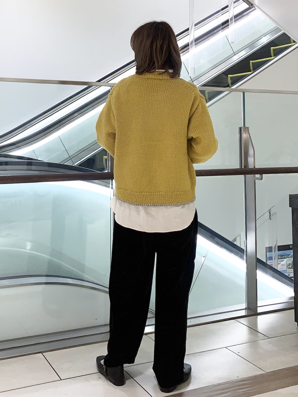 イエロー系のニット/セーター、ベージュ系のシャツ/ブラウス、ブラック系のその他パンツを着用したレディースの冬コーディネートの4枚目の写真