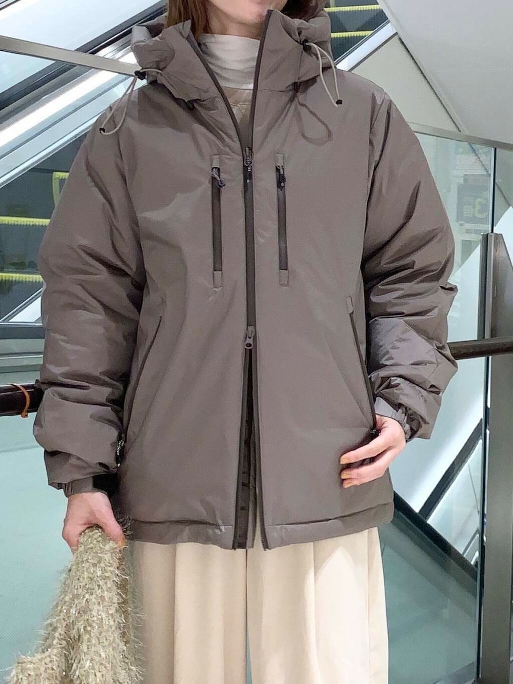 ホワイト系のTシャツ/カットソー、ブラウン系のダウンジャケット/コート、ブラック系のバレエシューズを着用したレディースの秋コーディネートの5枚目の写真