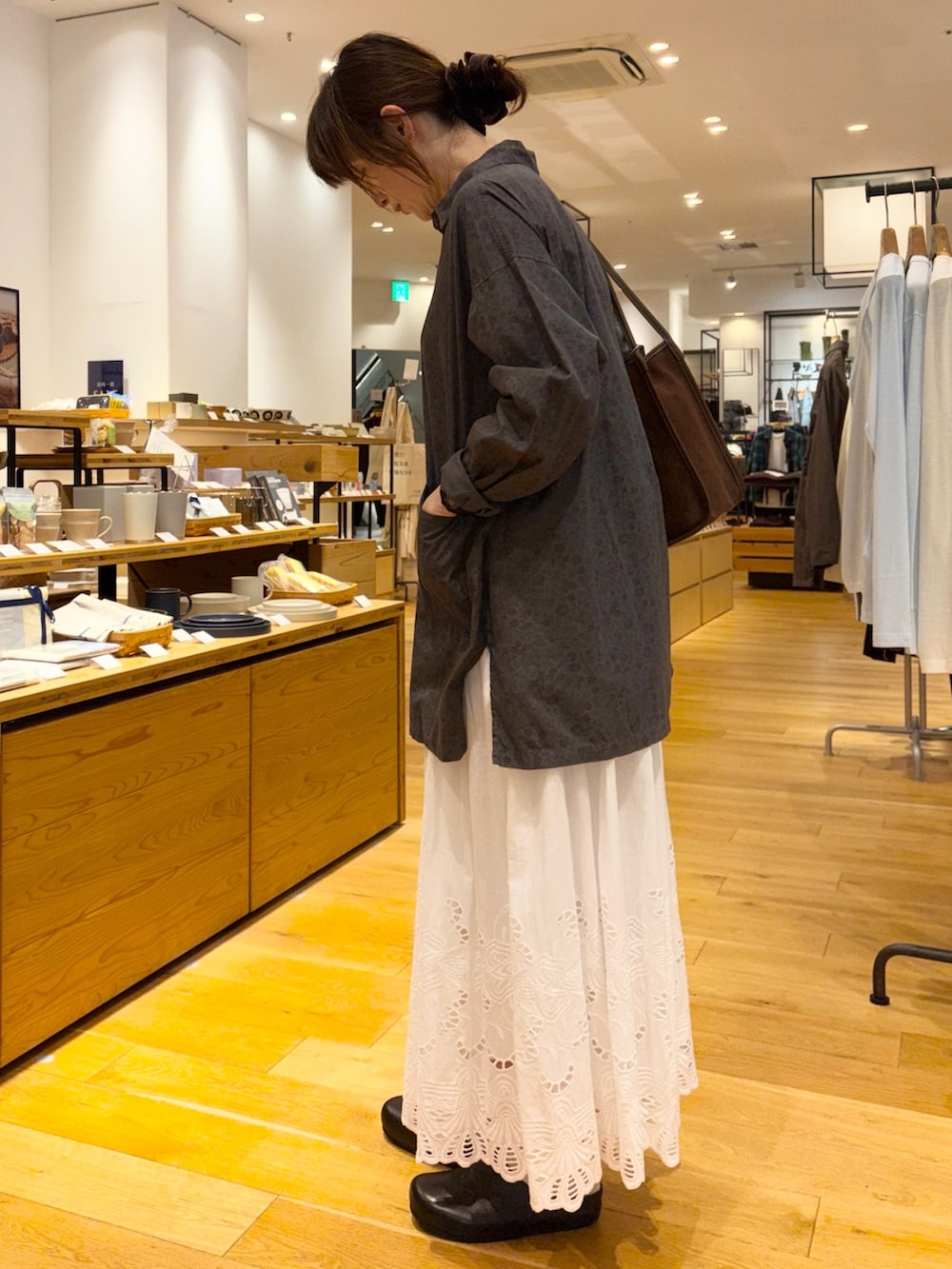 グレー系のシャツ/ブラウス、ホワイト系のスカート、ブラウン系のトートバッグを着用したレディースの秋コーディネートの4枚目の写真