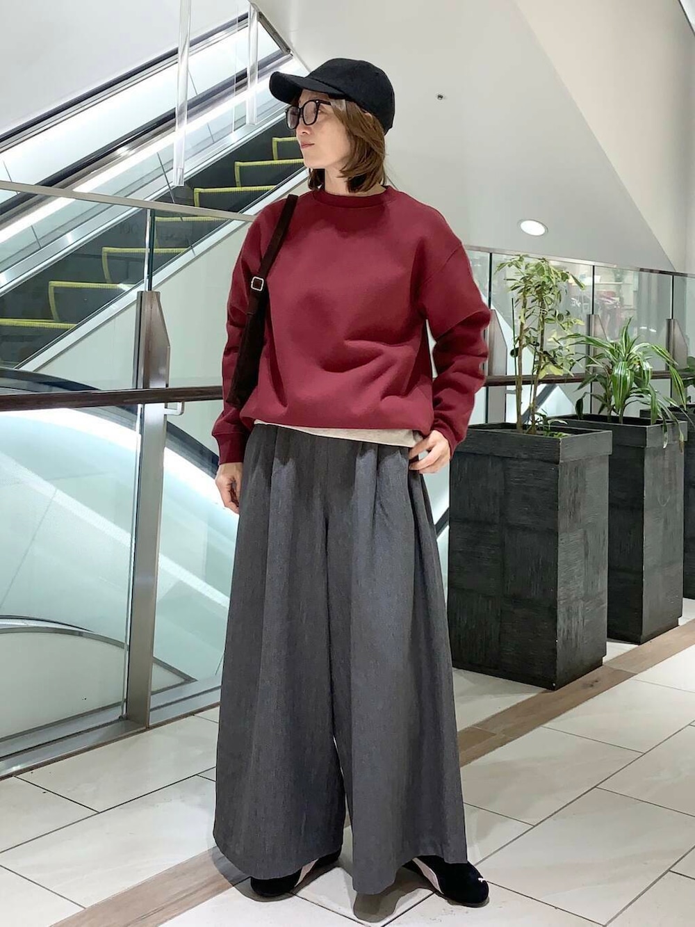 グレー系のその他パンツ、ブラウン系のショルダーバッグ、ベージュ系のTシャツ/カットソーを着用したレディースの冬コーディネートの3枚目の写真