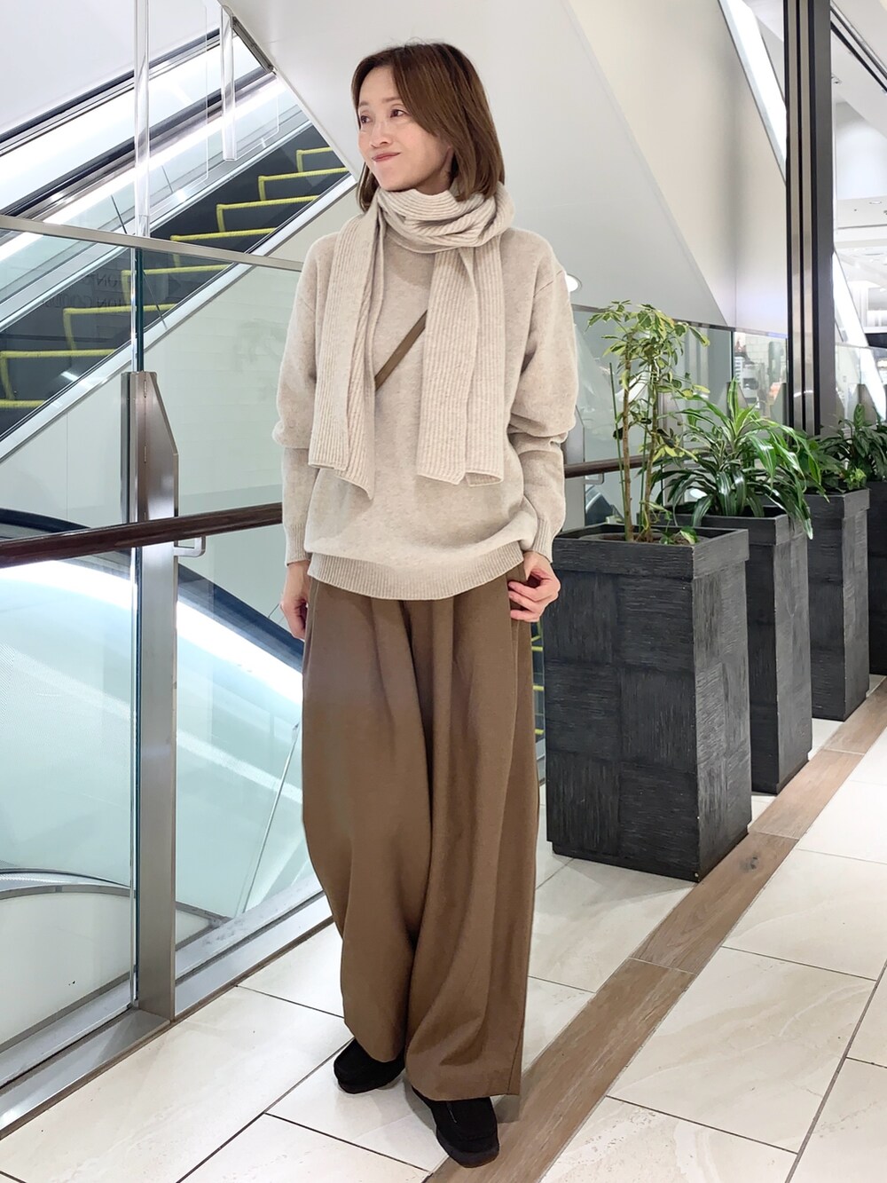 グレー系のその他パンツ、ベージュ系のニット/セーター、ブラウン系のショルダーバッグを着用したレディースの秋コーディネートの5枚目の写真