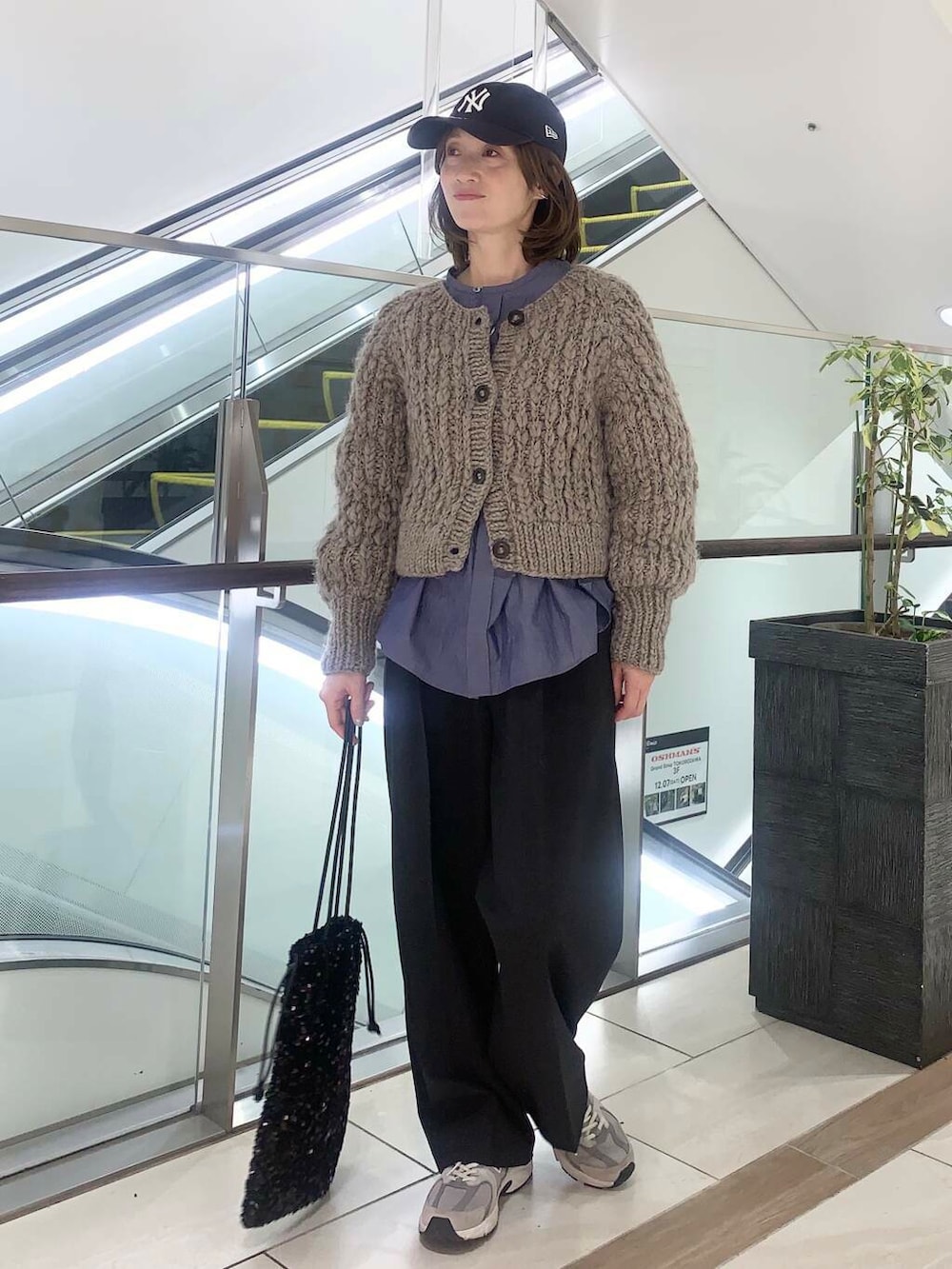 ブラウン系のカーディガン/ボレロ、ブラック系のトートバッグ、グレー系のその他パンツを着用したレディースの冬コーディネートの2枚目の写真
