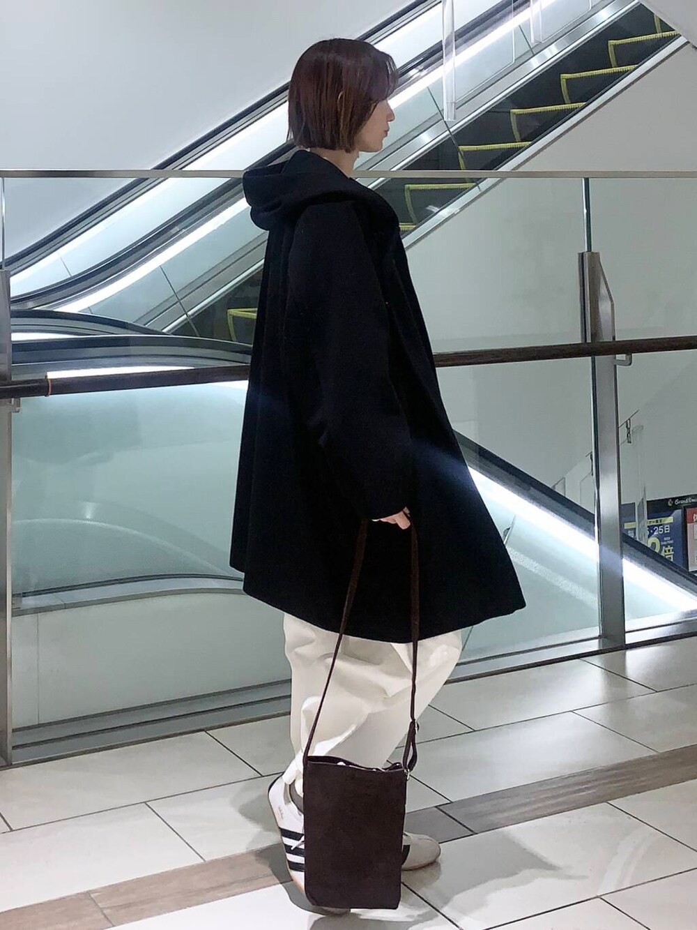 ホワイト系のその他パンツ、ブラウン系のショルダーバッグ、ブラック系のその他アウターを着用したレディースの冬コーディネートの5枚目の写真