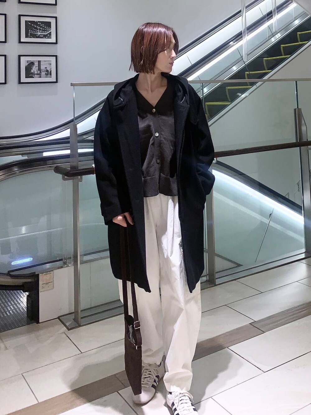 ホワイト系のその他パンツ、ブラウン系のショルダーバッグ、ブラック系のその他アウターを着用したレディースの冬コーディネートの4枚目の写真