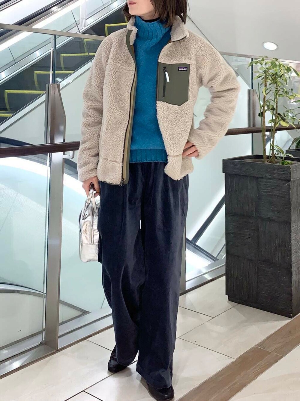 ブルー系のニット/セーター、シルバー系のショルダーバッグ、ブルー系のその他パンツを着用したレディースの冬コーディネートの5枚目の写真